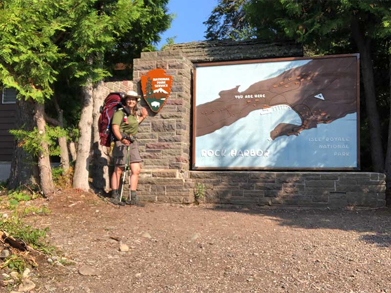 Standing in front of the Rock Harbor sign at Isle Royale National Park
